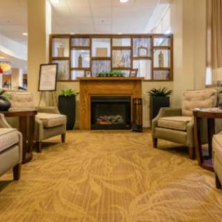 A cozy hotel lobby with comfortable seating around a fireplace.