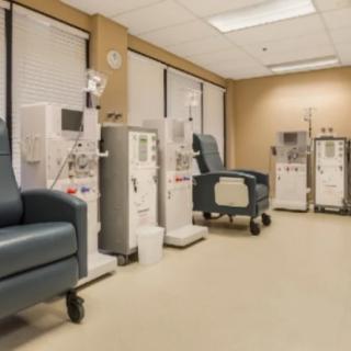 A clean and well-equipped dialysis clinic with medical chairs lined up next to advanced dialysis machines.