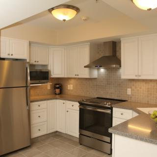 A modern kitchen featuring stainless steel appliances and white cabinetry.