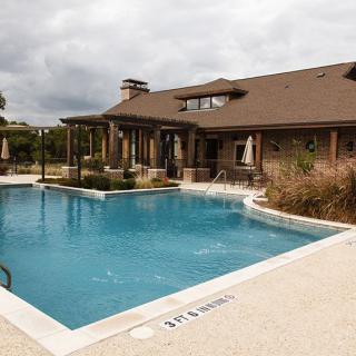 A residential house with an outdoor swimming pool and patio area.
