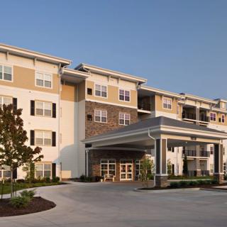A modern residential apartment building with a covered entrance.