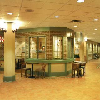 A well-lit indoor lobby area with seating arrangements and decorative brick walls.