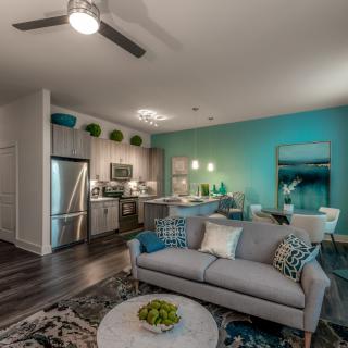 A modern open-plan living space featuring a sleek kitchen, cozy living room, and dining area with contemporary decor.