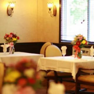 A cozy restaurant dining area with elegantly decorated tables featuring floral arrangements.