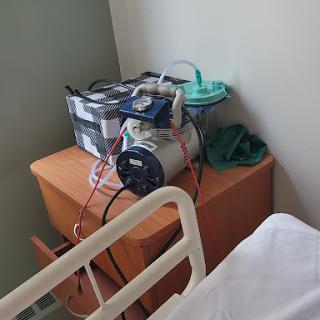 Medical equipment placed on a bedside table in a hospital room.
