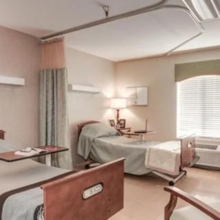 A hospital room with two beds and basic amenities.