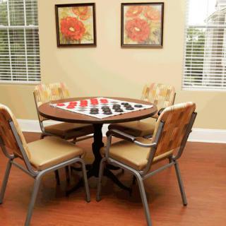 A cozy room featuring a round table with four chairs and artwork on the walls.