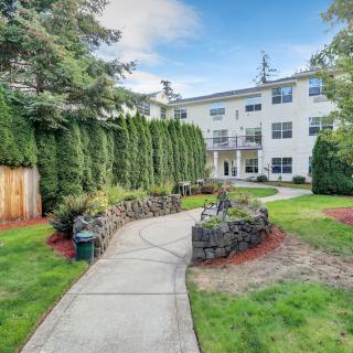 A well-maintained pathway leading through a landscaped garden to a modern apartment building.