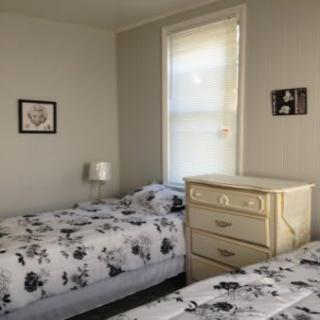 A cozy bedroom with twin beds and a dresser.