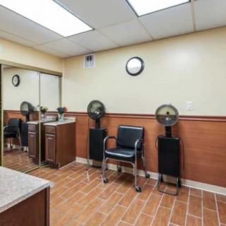 An interior view of a salon waiting area with styling chairs and fans.