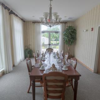 A formal dining room with an elegantly set table and a chandelier.