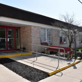 A view of a building entrance featuring an accessibility ramp.
