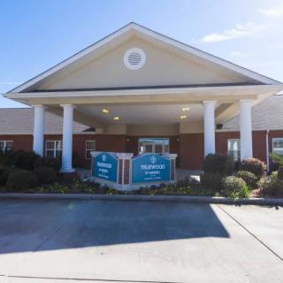 The image shows the entrance of a building with prominent columns and a pitched roof.