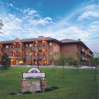 A picturesque view of a resort building with landscaped grounds and prominent signage at dusk.