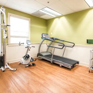 A well-equipped fitness room featuring a treadmill and stationary bike, ideal for workouts.