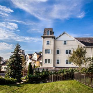 A beautiful house with a lush green lawn under a bright blue sky.