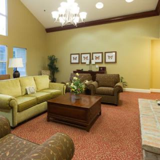 A cozy living room with a sofa, armchairs, and a chandelier.