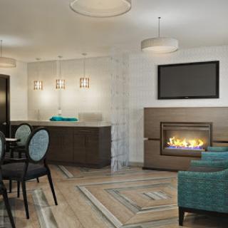 A cozy modern living room featuring a fireplace, stylish furniture, and elegant lighting.