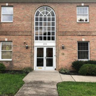 A brick building featuring a large arched entrance with several windows.