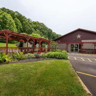 A building with a star emblem surrounded by a well-maintained garden and pergola.