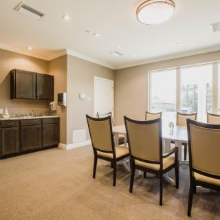 A modern dining area with a table, chairs, and large windows allowing natural light.