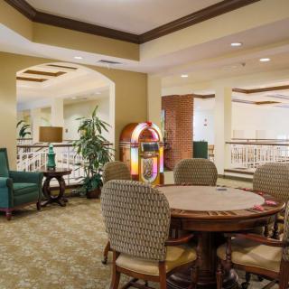 A cozy indoor seating area with a table, chairs, and a jukebox.
