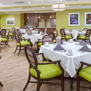 A well-lit dining room with neatly arranged tables and chairs, featuring elegant decor.