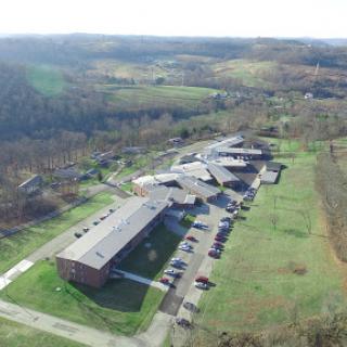 An aerial view of a school building situated in a serene rural landscape.