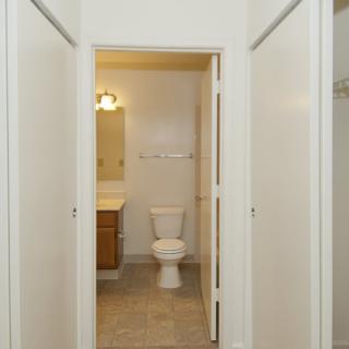 A clean and simple bathroom view with a toilet, sink, and mirror.