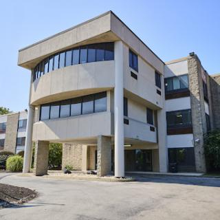 A modern commercial building featuring a unique architectural design with large windows.