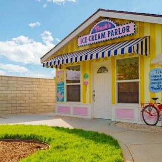 A colorful ice cream parlor with a vintage bicycle parked outside on a sunny day.