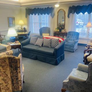 A cozy living room featuring various seating options and warm lighting.