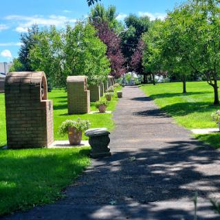 A serene pathway lined with trees and decorative planters, inviting visitors to explore the lush park.