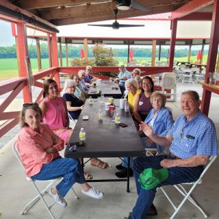 A group of people enjoying a social gathering at an outdoor picnic area.