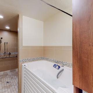 A stylish and modern bathroom featuring a spacious bathtub and elegant tile work.