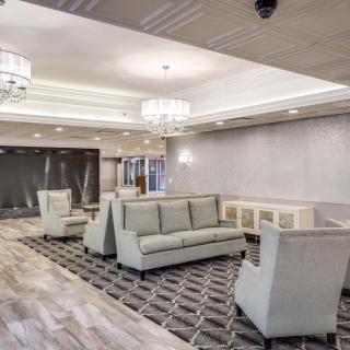A modern hotel lobby with elegant seating and bright chandeliers.