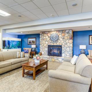 A cozy living room with comfortable sofas, a stone fireplace, and modern decor.