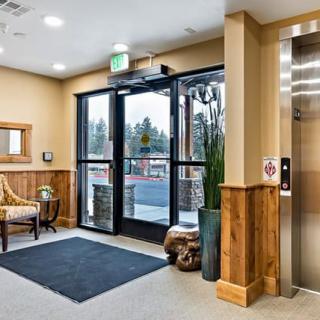 A welcoming lobby with an elevator, seating area, and glass doors leading outside.