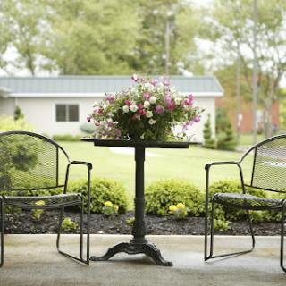 A serene outdoor seating area adorned with a floral centerpiece.