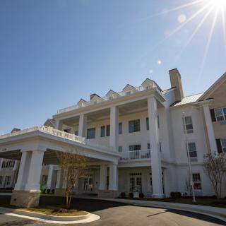 A large white building with columns under a bright sunny sky.