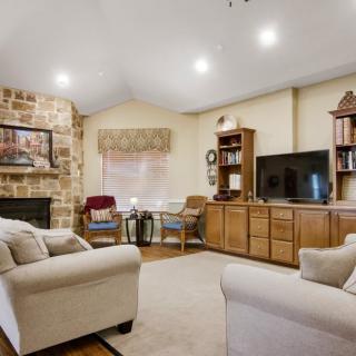 A cozy living room with comfortable seating, a TV, and a fireplace.