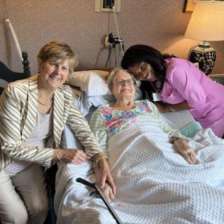 A heartwarming moment shared between a patient and her loved ones in a hospital setting.