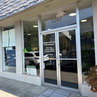 A modern storefront with a glass door and visible business signage.