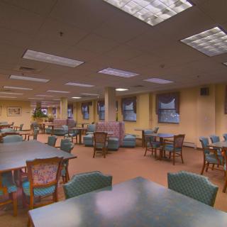 A spacious, well-lit dining area with multiple tables and chairs.