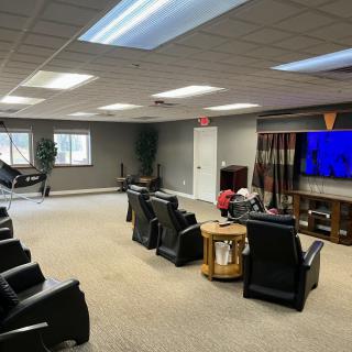 A spacious home theater room with comfortable seating and a large television.