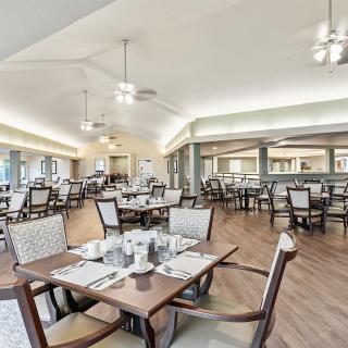 A spacious and elegantly arranged dining area with neatly set tables and comfortable seating.