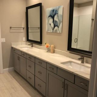 A modern bathroom featuring a double sink vanity with large mirrors and neutral decor.