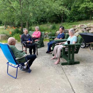 A group of friends enjoying a leisurely conversation outdoors.