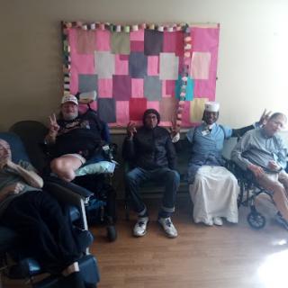 A diverse group of individuals enjoying their time together indoors, each posing with peace signs.