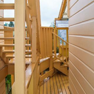 A wooden deck with stairs and railings leading to an outdoor area.